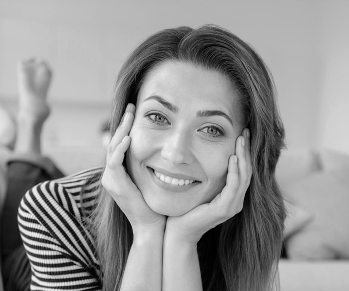 a woman who is smiling and looking at the camera a woman who is smiling and looking at the camera